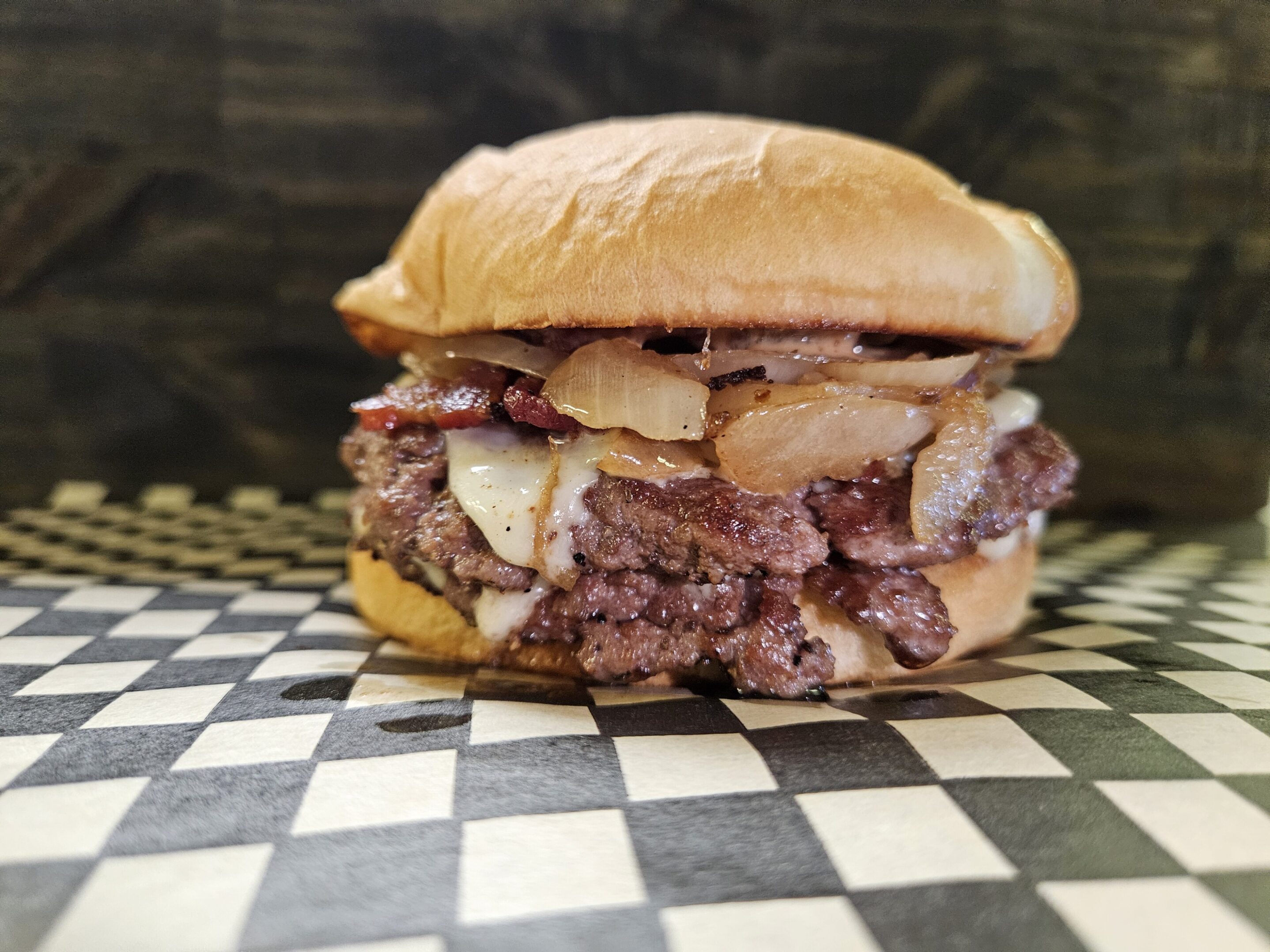 Juicy burger with crispy bacon and melted cheese on a soft bun.